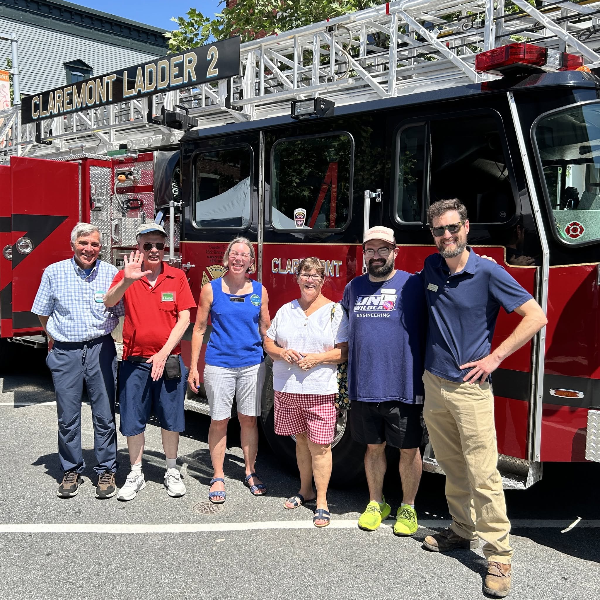 John Cloutier and community members in front of the Claremont Ladder 2 fire truck at a downtown event