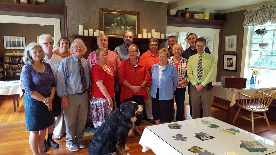 John Cloutier with community members and a Bernese mountain dog at a local house gathering