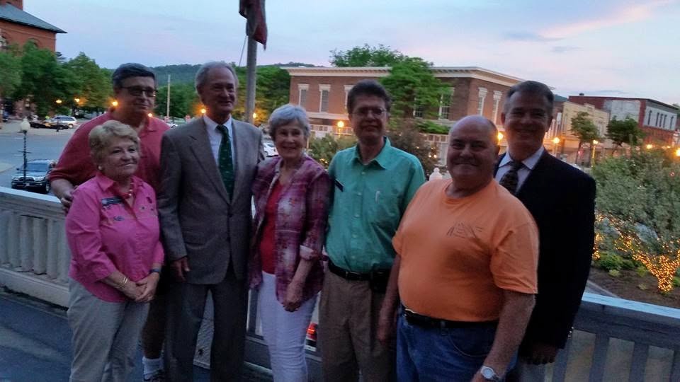 John Cloutier with neighbors and fellow Democrats on a porch overlooking downtown Claremont at dusk